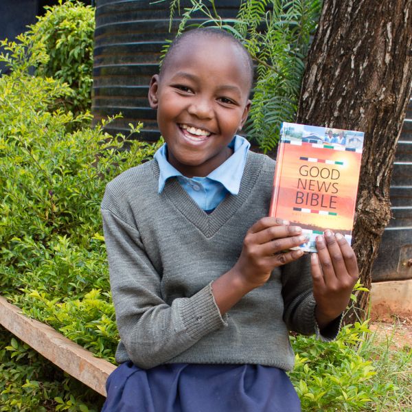 Otieno, een schoolmeisje van 15 jaar laat haar Bijbel zien. Ze lacht.